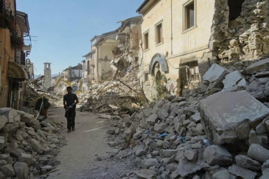 A man walks by plenty of the collapsed buildings after an earthquake hit Italy. Image Credit: NY Times