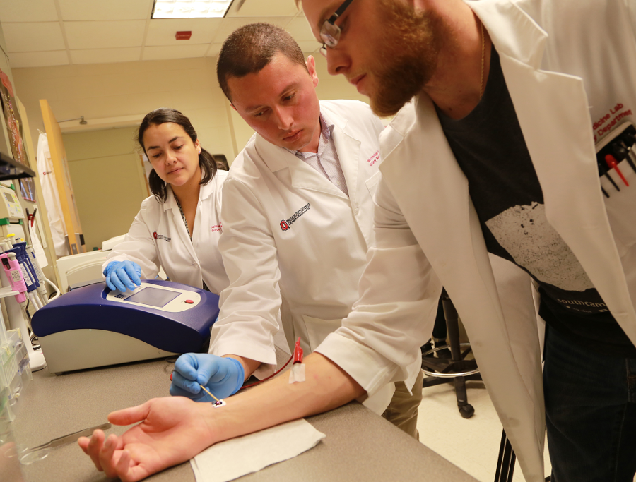 Daniel Gallego-Perez, Ph.D. demonstrating tissue nanotransfection, using a silicone chip to convert skin cells into other types of cells. Image Credit: The Ohio State University Wexner Medical Center