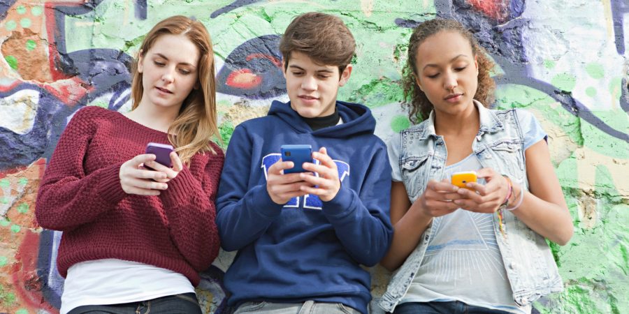 Teenagers using their smartphones simultaneously. Image Source: Huffington Post